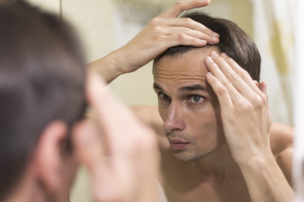 Man worried about hair loss, considering GFC treatment for hair.