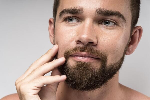 Man admiring beard after successful beard transplant
